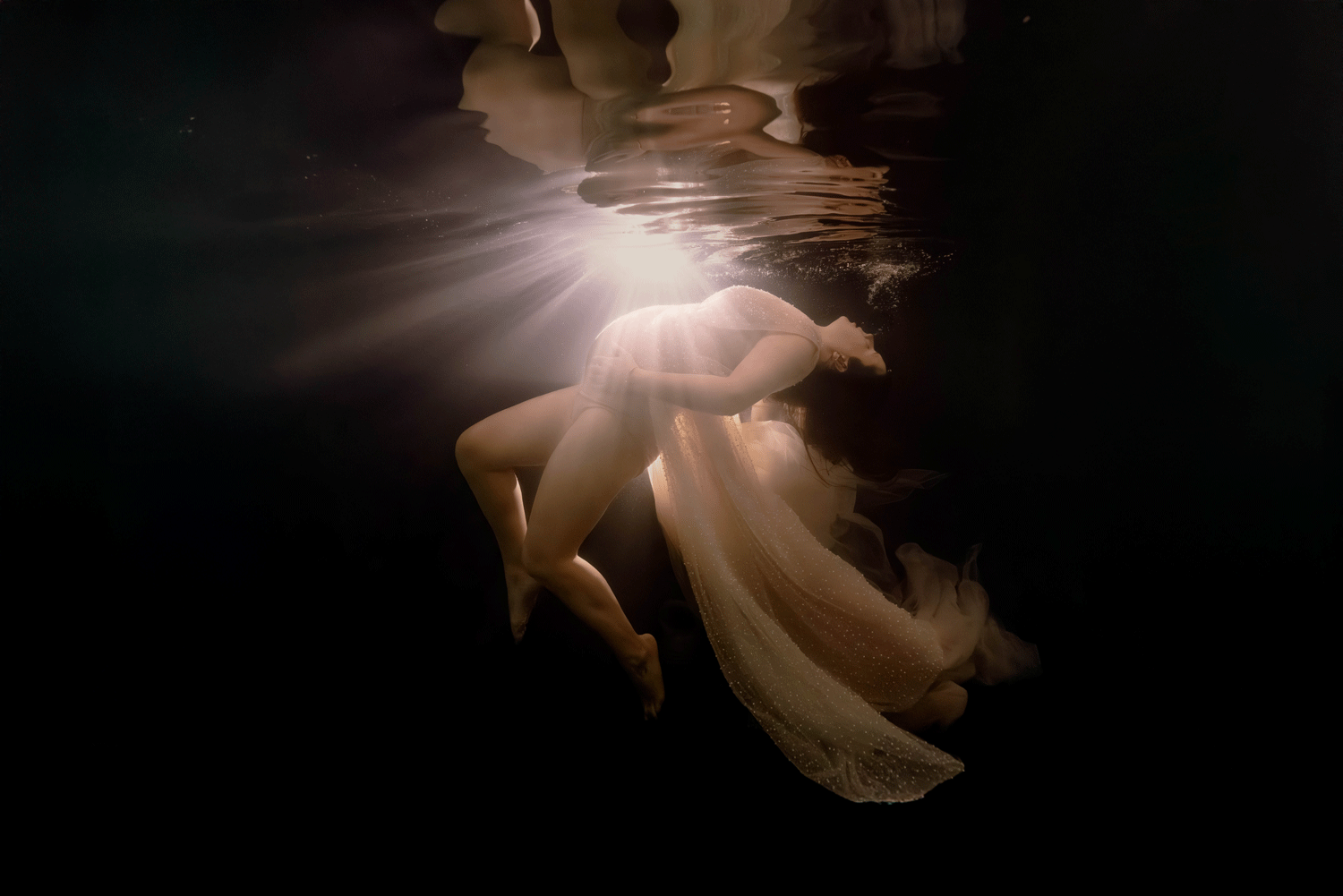 Jeux de lumière underwater lors d’une séance grossesse